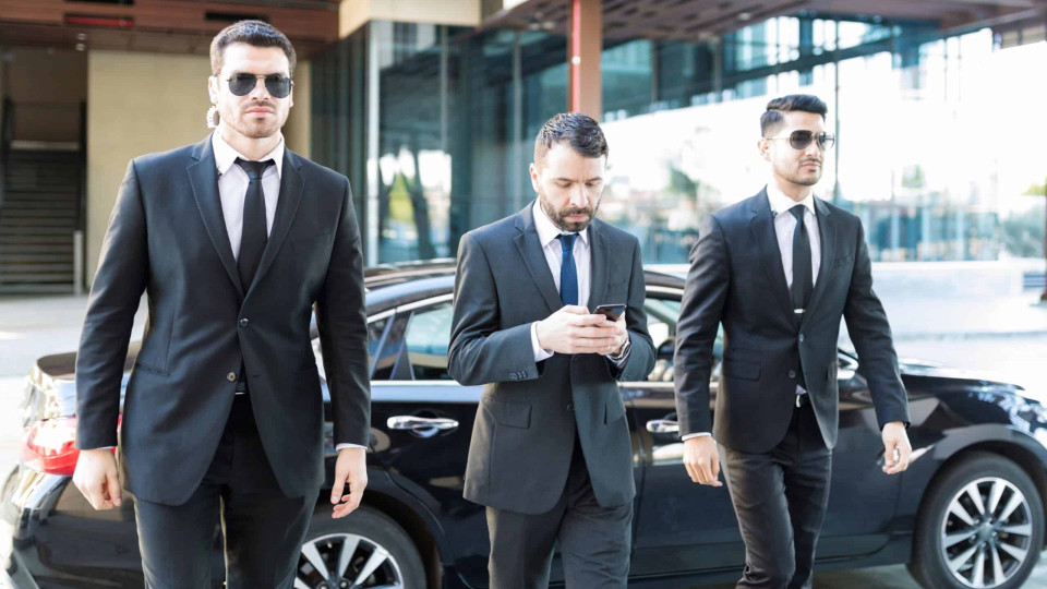 Service agents escorting entrepreneur messaging on mobile phone at campus